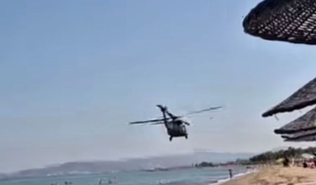 Alçak uçuş yapan helikopter plajda ilgi odağı oldu