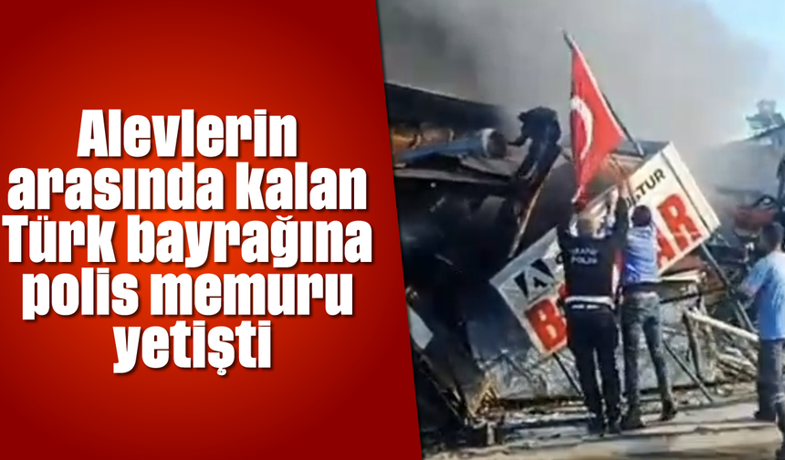 Alevlerin arasında kalan Türk bayrağına polis memuru yetişti